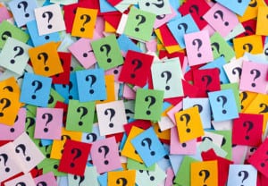 Too Many Questions. Pile of colorful paper notes with question marks. Closeup.