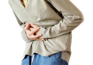 boy holding hands on his stomach over white background, pain
