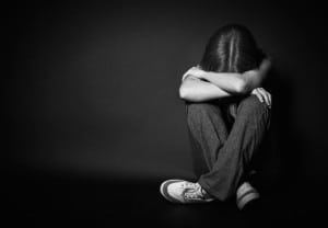 sad woman in depression and despair crying on black dark background