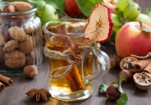 apple cider with spices in glass mug, close-up